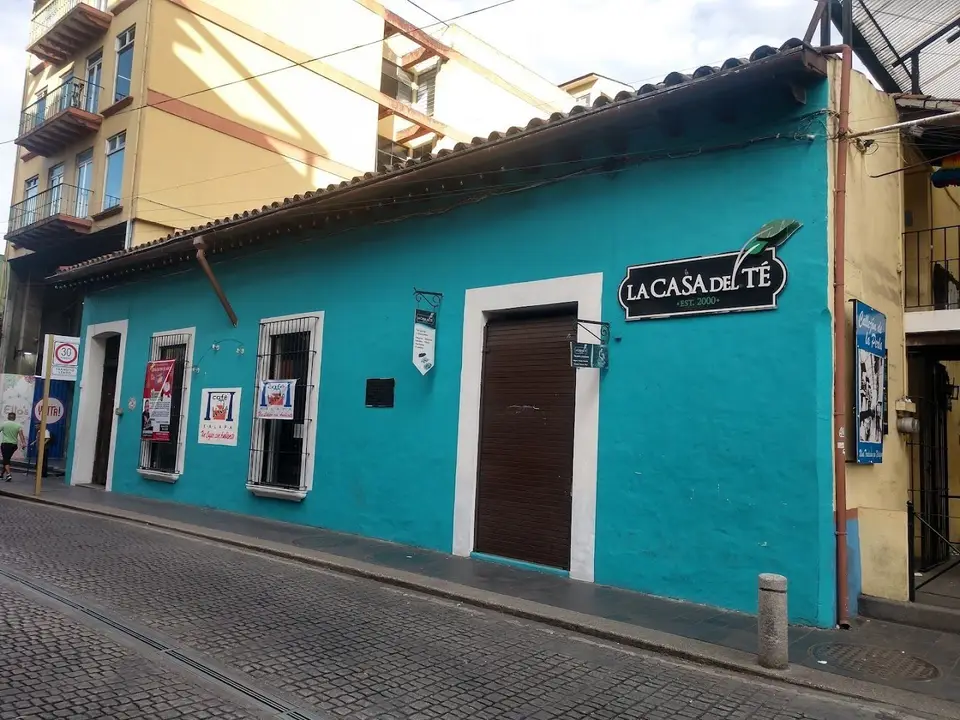 Fachada turquesa en Primo Verdad con los carteles de Café Lindo en las ventanas