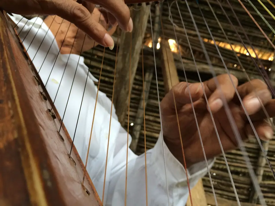 Manos tocando un arpa
