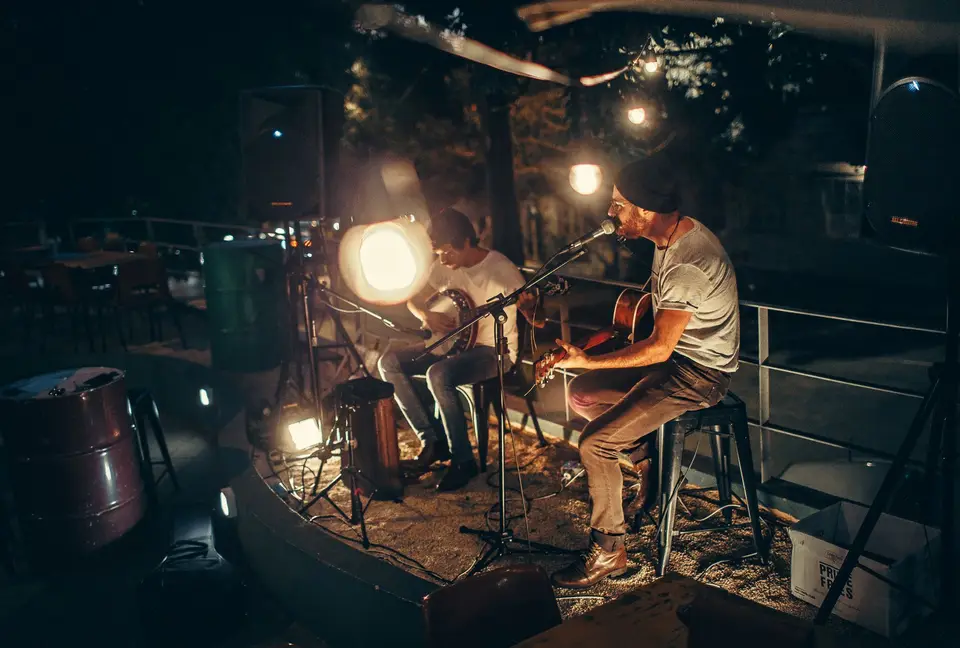 Dos músicos tocando guitarra de noche