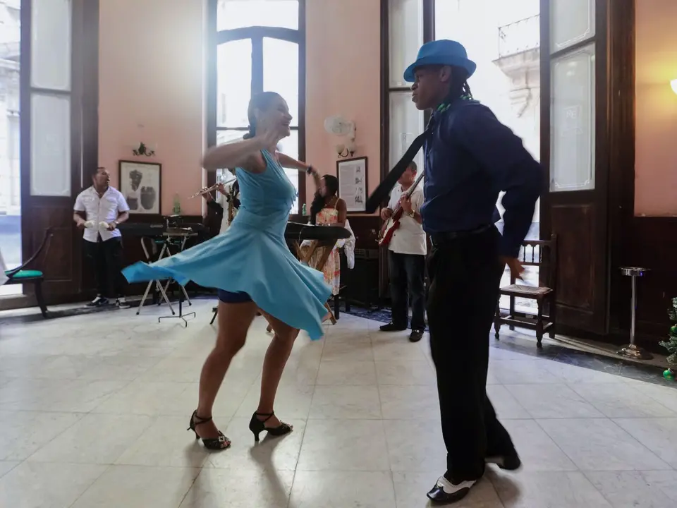 Pareja bailando salsa frente a una banda en vivo